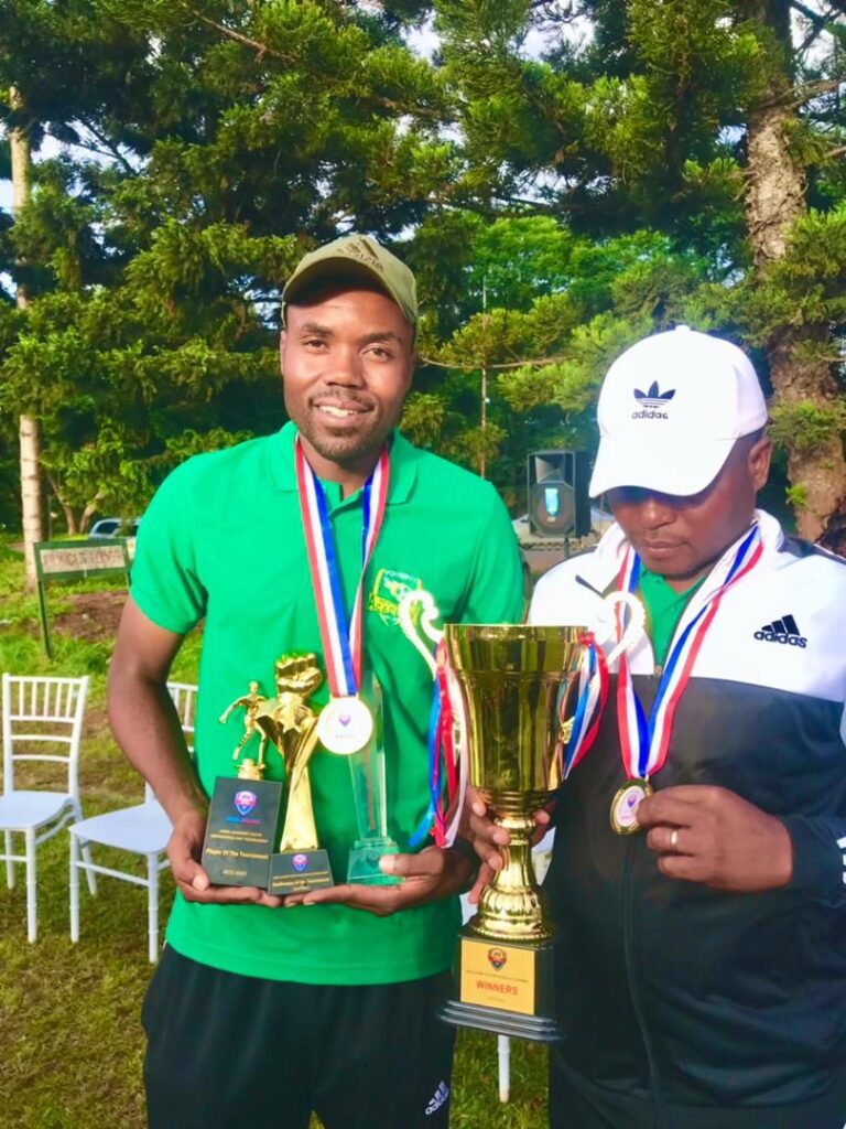 Power11 director, Tapiwa Ndewere 9in green) posing for a photo with JFA U-16 trophy